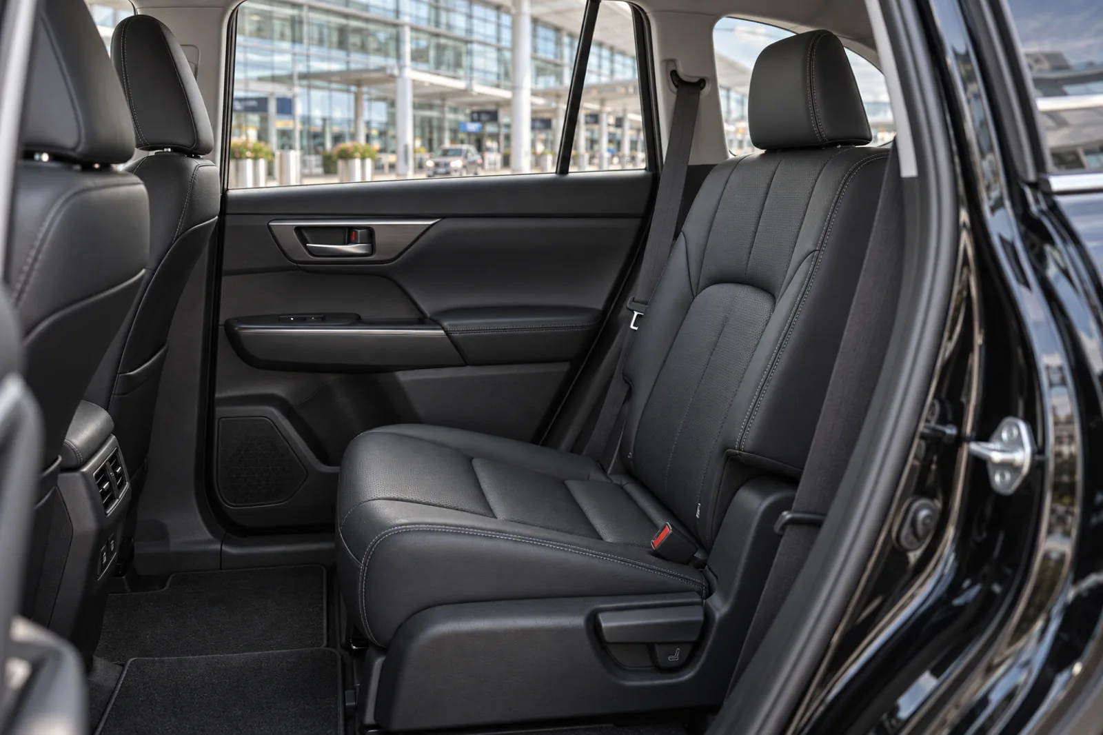 Black leather rear passenger seats inside a Toyota Highlander Hybrid airport limo